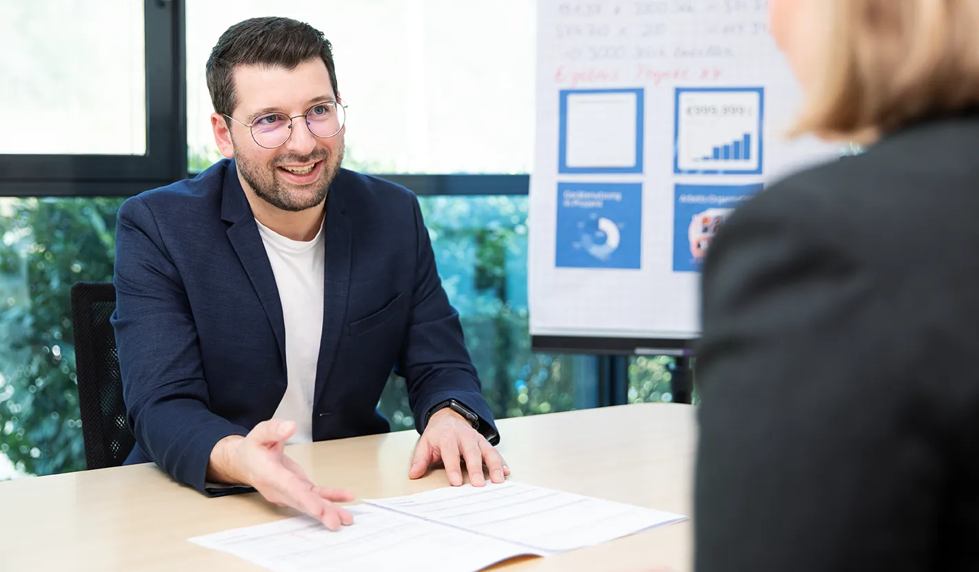 TechniSat consultant advises a customer about HD upgrade options in a friendly atmosphere.
