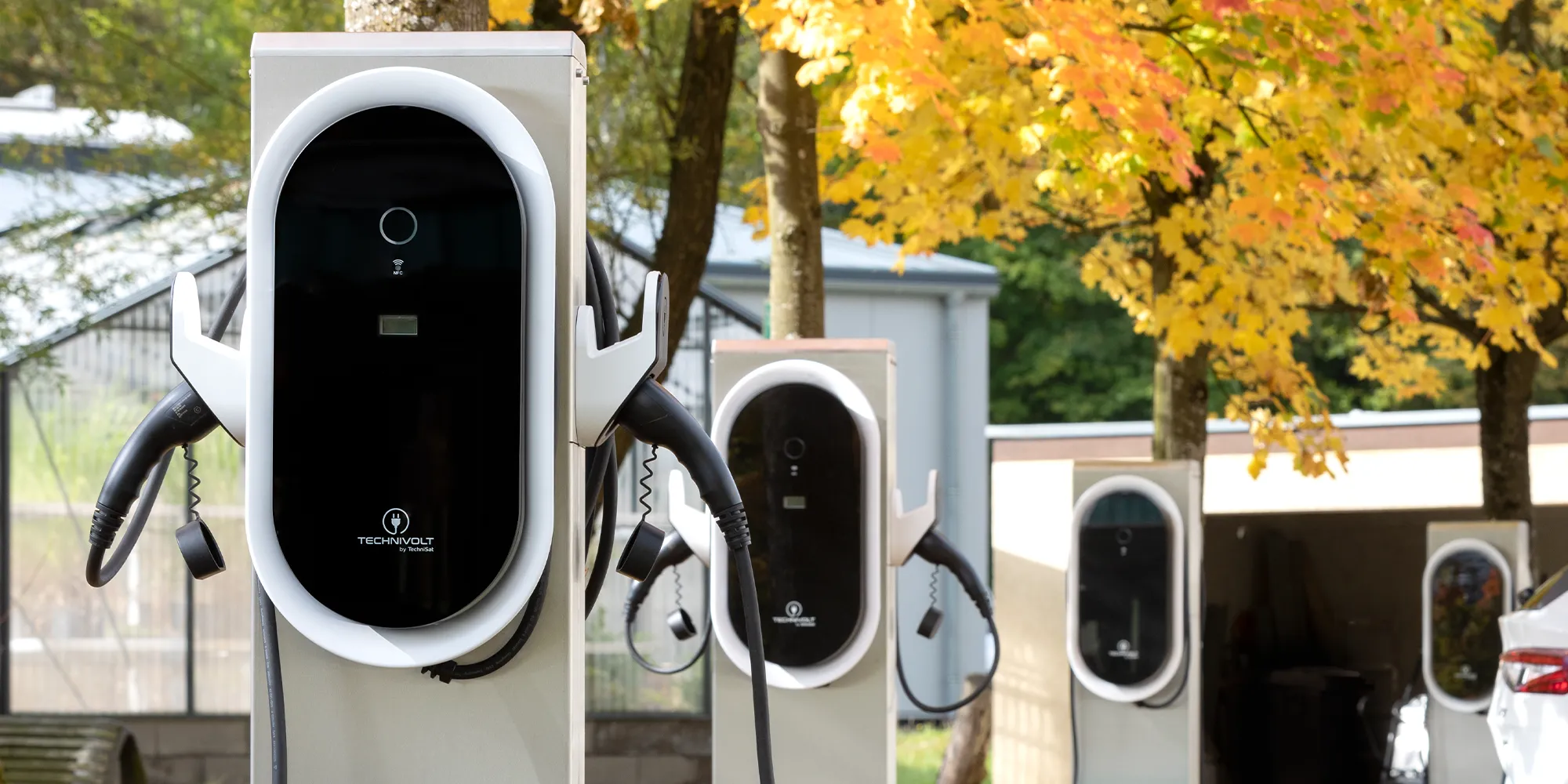 Firmenparkplatz mit mehreren Ladepunkten und einem Elektroauto – zeigt Ladelösungen für Unternehmen.